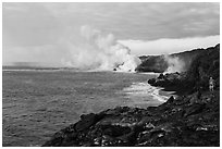 Hiker and volcanic steam cloud on coast. Hawaii Volcanoes National Park, Hawaii, USA. (black and white)