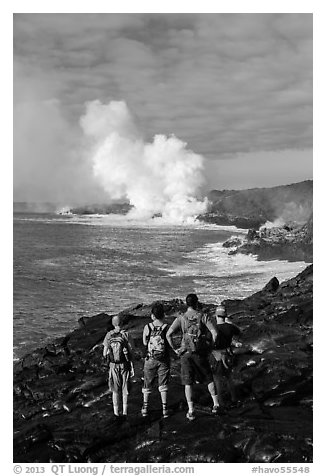 Hikers looking at molten lava and coastal volcanic steam cloud. Hawaii Volcanoes National Park (black and white)