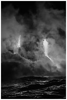 Lava cascading cliffs above ocean waves at night. Hawaii Volcanoes National Park, Hawaii, USA. (black and white)
