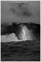 A single spigot of lava creates a large plume steam at sunrise upon reaching ocean. Hawaii Volcanoes National Park, Hawaii, USA. (black and white)