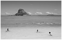 Family in the waters of Kualoa Park with Chinaman's Hat in the background. Oahu island, Hawaii, USA ( black and white)