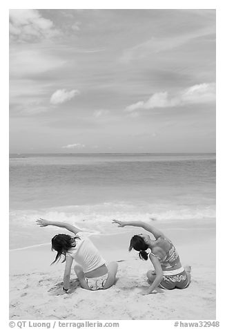 Young women doing gymnastics on Waimanalo Beach. Oahu island, Hawaii, USA