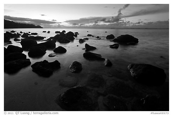 Boulders in water near Kalihika Park, sunset. Kauai island, Hawaii, USA (black and white)