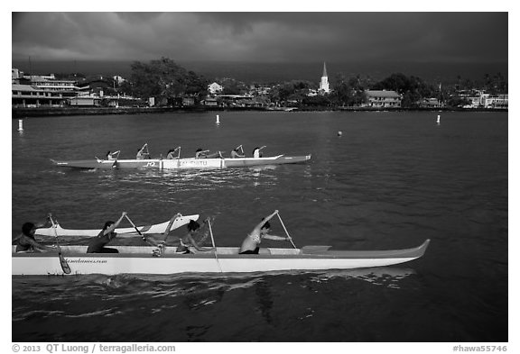 Outrigger canoes and town under storm sky, Kailua-Kona. Hawaii, USA (black and white)