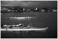 Outrigger canoes and town under storm sky, Kailua-Kona. Hawaii, USA (black and white)