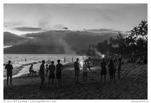 Revelers on Kamahole Beach with fireworks, Kihei. Maui, Hawaii, USA (black and white)
