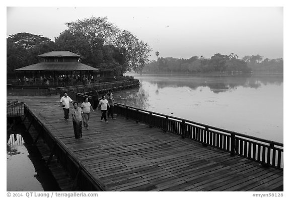 People walking for exercise at dawn, Kandawgyi Lake Park. Yangon, Myanmar (black and white)