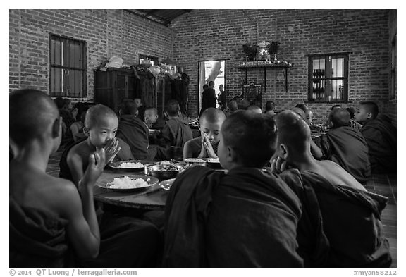 Buddhist novices pray at table before eating lunch, Nyaung U. Bagan, Myanmar (black and white)