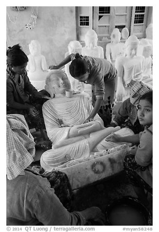 Women polishing buddha statue. Mandalay, Myanmar (black and white)