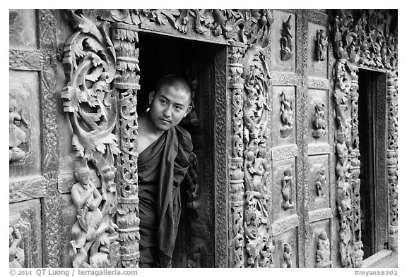 Exquisitely carved teak walls and monk pearing, Shwe In Bin Kyaung pagoda. Mandalay, Myanmar (black and white)