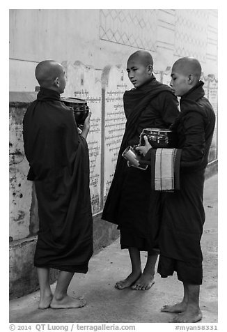 Three monks conversing at Mahagandayon Monastery. Amarapura, Myanmar (black and white)