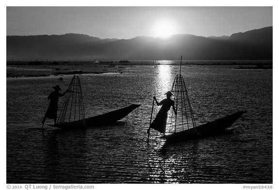Intha fishermen row with leg with setting sun. Inle Lake, Myanmar (black and white)