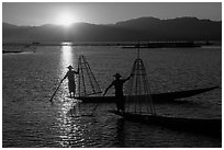 Intha fishermen on long flat-bottomed boats at sunset. Inle Lake, Myanmar ( black and white)