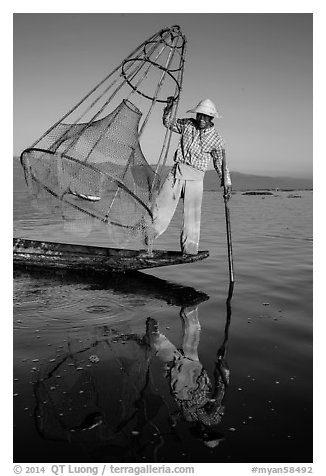 Intha fisherman with freshly caught fish in basket. Inle Lake, Myanmar (black and white)