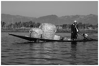 Man transporting baskets on boat. Inle Lake, Myanmar ( black and white)