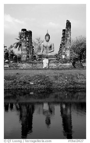 Buddha image reflected in moat, morning, Wat Mahathat. Sukothai, Thailand (black and white)