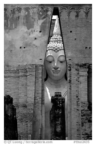 Monumental Buddha image seen between walls,  Wat Si Chum. Sukothai, Thailand (black and white)