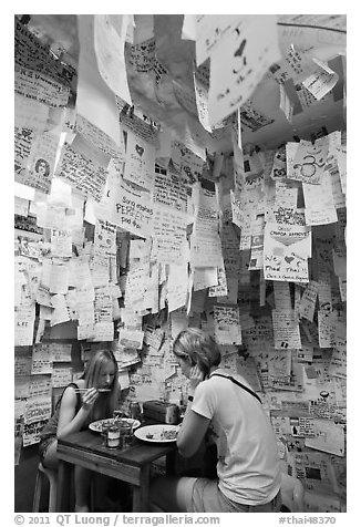 Women eating at Pad Thai restaurant decorated with customer notes, Ko Phi-Phi Don. Krabi Province, Thailand (black and white)