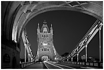 Arch and car traffic on the Tower Bridge at night. London, England, United Kingdom (black and white)