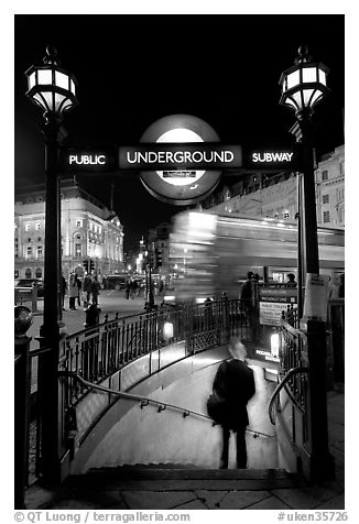 Man entering underground, and motion-blurred double decker bus,  Piccadilly Circus. London, England, United Kingdom (black and white)
