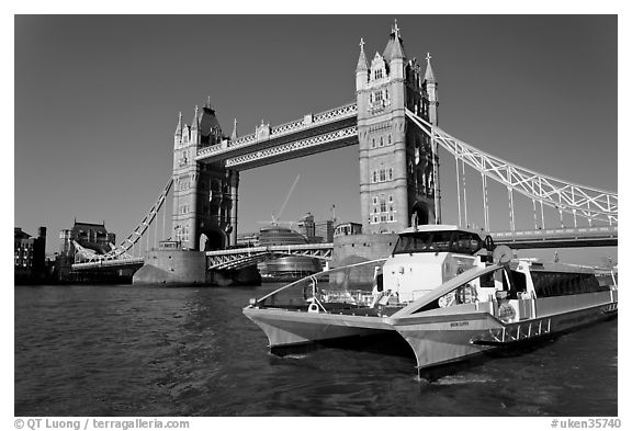 Fast catamaran cruising the Thames, with Tower Bridge in the background. London, England, United Kingdom (black and white)