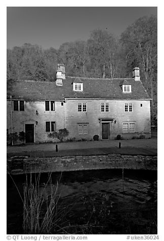 Cotswold type houses and Bybrook River, Castle Combe. Wiltshire, England, United Kingdom (black and white)