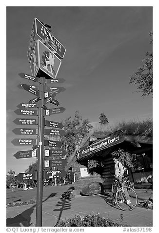 Sign Air Crossroads of the World, man on bicycle in front of visitor center. Anchorage, Alaska, USA