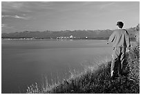 Man walking on the edge of Knik Arm in Earthquake Park, sunset. Anchorage, Alaska, USA (black and white)