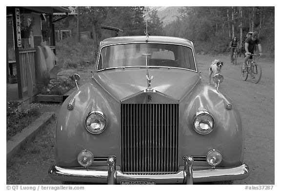 Rolls Royce on dirt road with mountain bikers in background. McCarthy, Alaska, USA