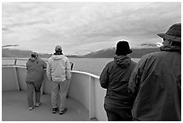 Passengers standing on deck with colorful  clothes. Seward, Alaska, USA (black and white)
