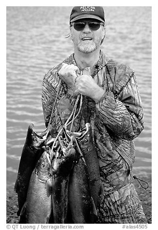 Fisherman carrying salmon freshly caught in the Fishing Hole. Homer, Alaska, USA (black and white)