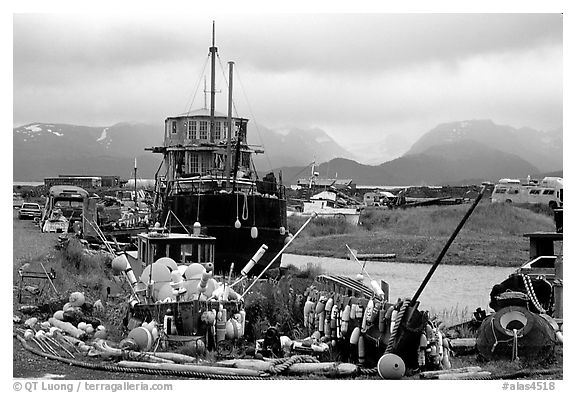 Retired fishing boat with a pile of marine gear on the Spit. Homer, Alaska, USA (black and white)
