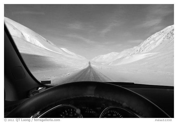 Road in wintry landscape seen from dashboard indicating -32F temperature. Alaska, USA (black and white)