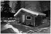 Snowy log cabin at night. Chena Hot Springs, Alaska, USA (black and white)