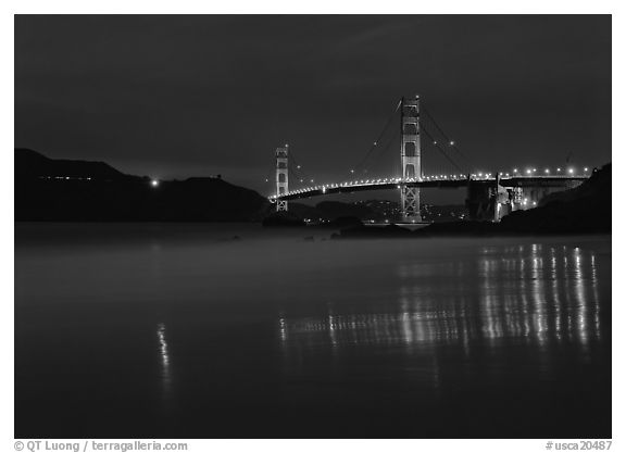 Golden Gate Bridge reflected in wet sand, blue hour. California, USA (black and white)