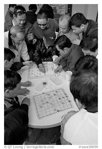 Vietnamese immigrants playing Chinese chess in a patio. San Jose, California, USA (black and white)
