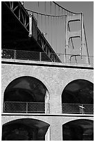 Arched galleries of Fort Point and Golden Gate Bridge pillar. San Francisco, California, USA (black and white)