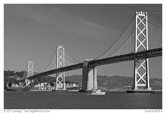 Cargo ship passing below the Bay Bridge. San Francisco, California, USA (black and white)