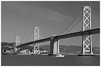 Cargo ship passing below the Bay Bridge. San Francisco, California, USA ( black and white)