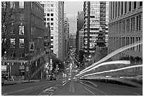 Cable-car rails,  Chinatown, Financial district, and Bay Bridge seen on California street. San Francisco, California, USA ( black and white)