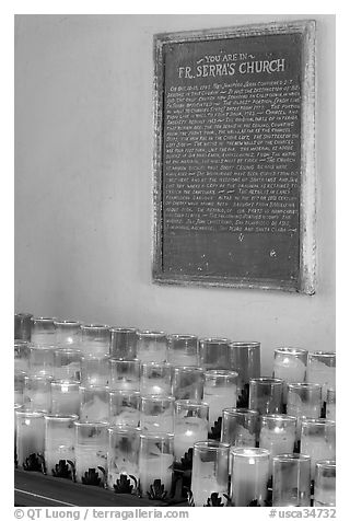 Rows of candles and sign commemorating Father Serra. San Juan Capistrano, Orange County, California, USA (black and white)