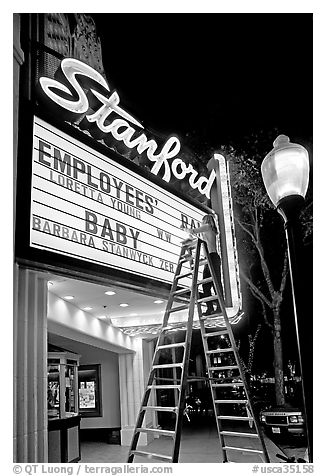 Woman on ladder arranging sign letters, Stanford Theater. Palo Alto,  California, USA (black and white)