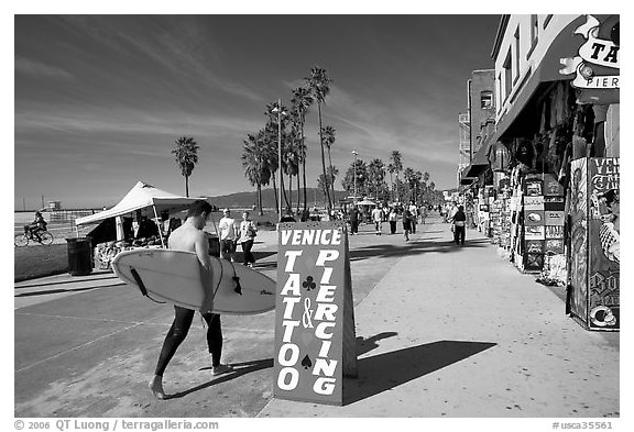 Surfer walking on Ocean Front Walk. Venice, Los Angeles, California, USA