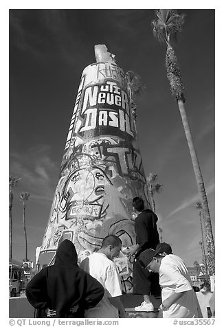 Young men decorating a cone on the beach. Venice, Los Angeles, California, USA (black and white)