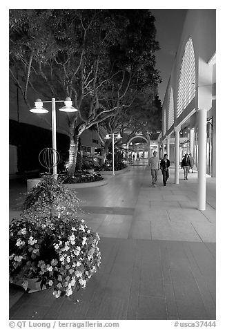 Couple walking by stores and flowers, Stanford Shopping Center. Stanford University, California, USA