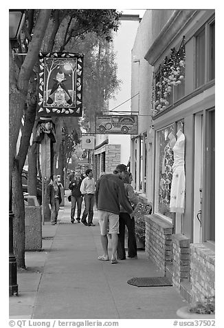 People looking at store display on Main Street. Half Moon Bay, California, USA (black and white)