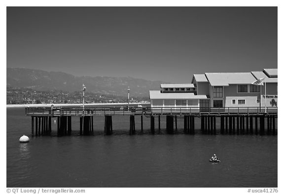 Man on buoy and pier. Santa Barbara, California, USA (black and white)