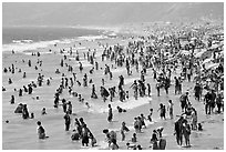 Crowds of beachgoers in water. Santa Monica, Los Angeles, California, USA (black and white)