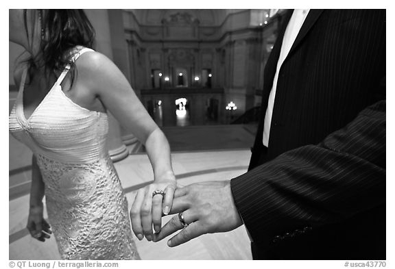 Newly wed couple holds hands, showing ring, City Hall. San Francisco, California, USA