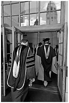Professors in academic regalia walk into door with Hoover tower reflected. Stanford University, California, USA (black and white)